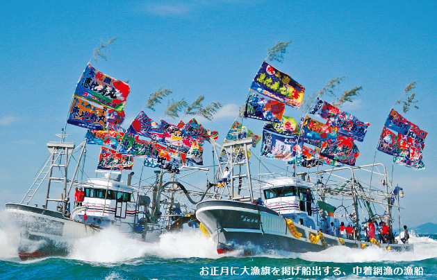 お正月に大漁旗を掲げ船出する、巾着網漁の漁船