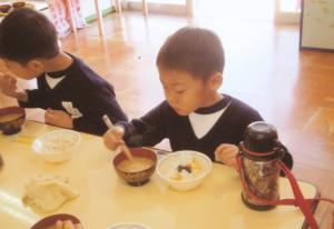 園児がおいもご飯を食べている写真です