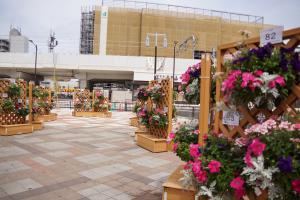 東岸和田駅をバックに、出展者のみさなんのお花のバスケットがたくさん飾られた全景のお写真です。