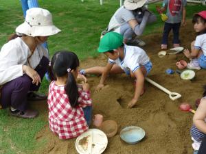 園児と未就園児が砂場で楽しく遊んでいます