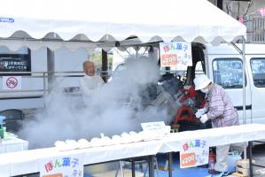 ポン菓子を作る機械をハンマーで叩いて煙がたくさん出ている写真