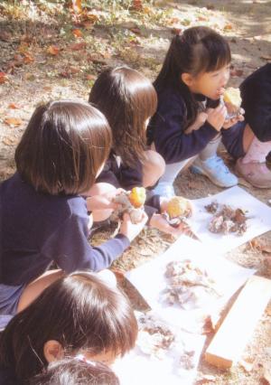 園児たちがやきいもを食べている写真です