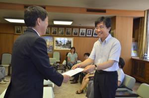 自治基本条例推進委員会委員長が市長に建議書を渡している写真
