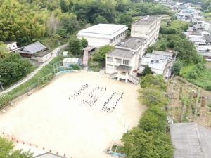 東葛城小学校を上空から撮影した写真、グランドには一文字で150の数字