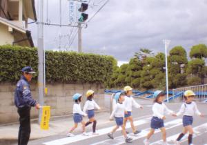幼稚園児が、信号を守って横断歩道をわたっています。