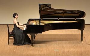 大槻夏子さんがグランドピアノを弾いている写真
