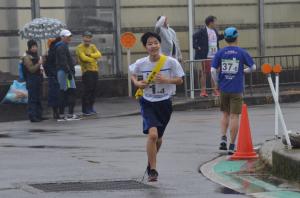 笑顔で走る男子中学生のランナー