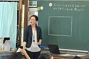 黒板の前で授業をする女性教師